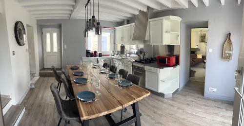 une table de salle à manger avec des chaises et une cuisine dans l'établissement CHEZ BRIGITTE, à Châtillon-sur-Marne