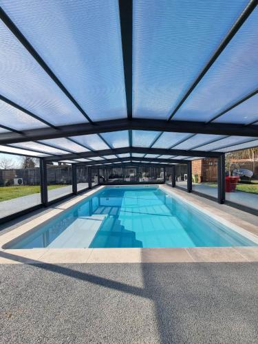 une grande piscine sous un grand toit dans l'établissement chalet Colonids 1, à Grues
