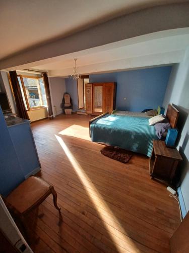 a bedroom with a bed and a wooden floor at Au jardin du lac in Gaussan
