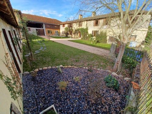 a yard with a pile of rocks in front of a building at Au jardin du lac in Gaussan