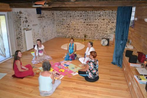 eine Gruppe von Frauen, die in einem Raum auf dem Boden sitzen in der Unterkunft Au jardin du lac in Gaussan