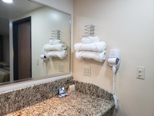 a bathroom with a mirror and a pile of towels at La Villa de Zaragoza in Tijuana