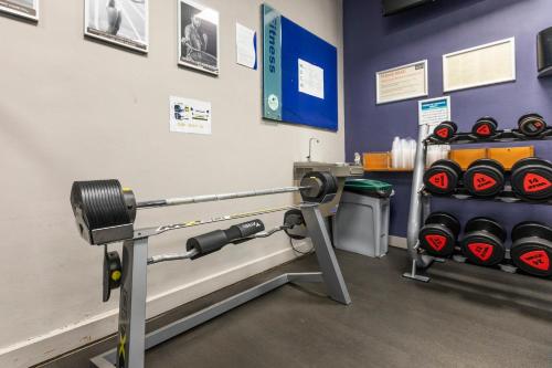 a gym with a bench with dumbbells in a room at Holiday Inn Brentwood by IHG in Brentwood