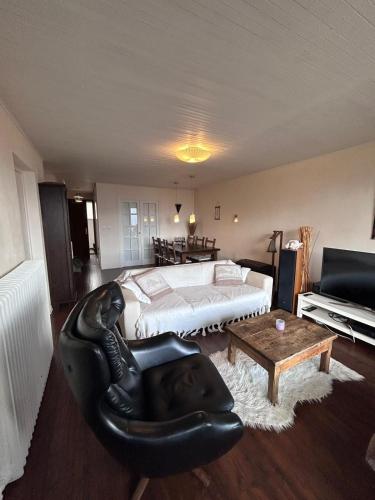 - une chambre avec un lit et un fauteuil en cuir noir dans l'établissement le panoramic, à L'Alpe-d'Huez