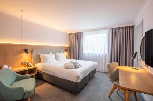 a hotel room with a bed and a chair at Holiday Inn Brentwood by IHG in Brentwood