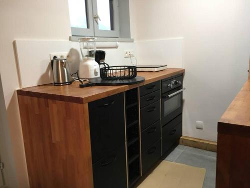 - une cuisine avec un comptoir en bois et une cuisinière dans l'établissement Lyret - Centre ville, vue MontBlanc, parking, wifi, à Chamonix-Mont-Blanc