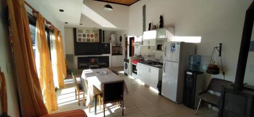 una cucina con tavolo e frigorifero bianco di HERMOSA CASA 2 DORMITORIOS EN POTRERO DE GARAY a Potrero de Garay