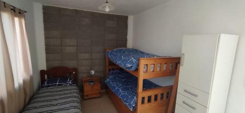 two bunk beds in a small room with a refrigerator at HERMOSA CASA 2 DORMITORIOS EN POTRERO DE GARAY in Potrero de Garay