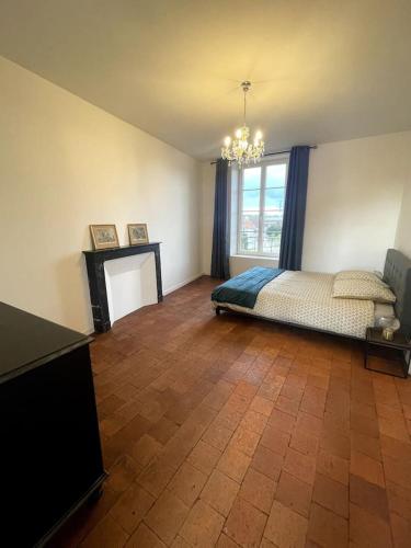 a bedroom with a bed and a television and a window at Gite les Minimes II in Avallon