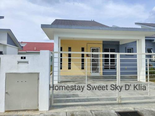 a house with a gate in front of it at Homestay KLIA Sweet Sky in Sepang