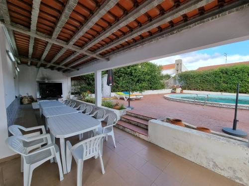 eine Terrasse mit einem Tisch und Stühlen sowie einem Pool in der Unterkunft Quinta D'Avó in Setúbal