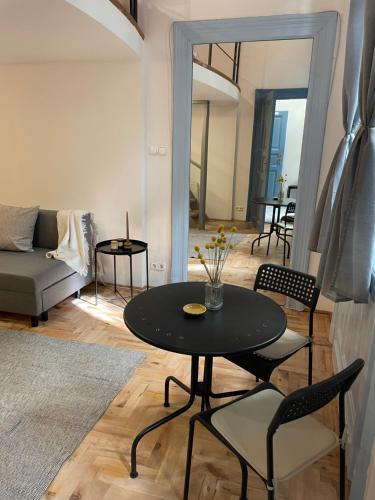 einen schwarzen Tisch und Stühle im Wohnzimmer in der Unterkunft Blue Mirror Apartment in Budapest