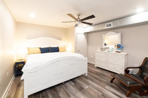 1 dormitorio blanco con 1 cama blanca y 1 silla en Blaizy Dayz, en Bay Saint Louis