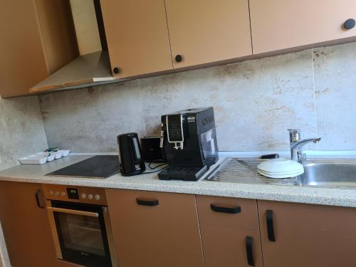 un bancone della cucina con macchinetta del caffè e lavandino di MyHomeInMünchen a Monaco