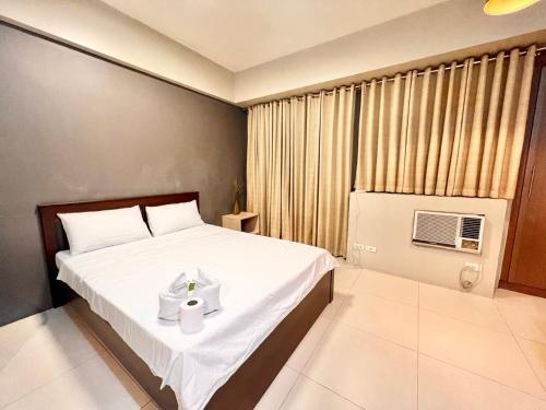 una camera da letto con un letto e un asciugamano sopra di Elegant Condo Hotel across NAIA Airport Terminal 3 Newport City a Manila