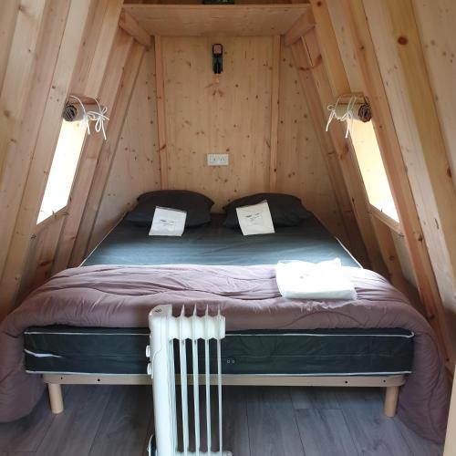 - une chambre dans une cabane en rondins avec un lit dans l'établissement Camping Pyrénées Nature, à Oloron-Sainte-Marie