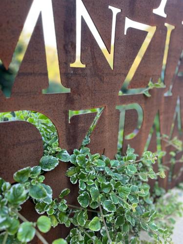 a green plant next to a sign that says new park at Tenuta Zamparina in Montignoso