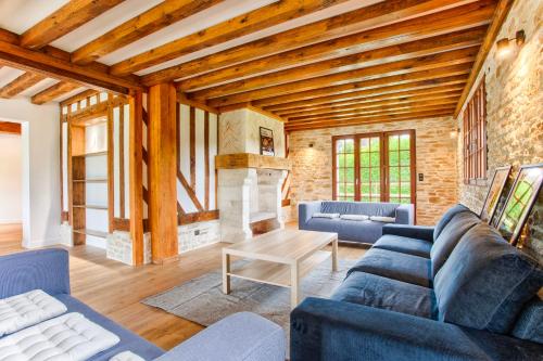 a living room with a blue couch and a table at Villa Paséo - Swimming pool and large garden - Near Deauville and Trouville in Bonneville-sur-Touques