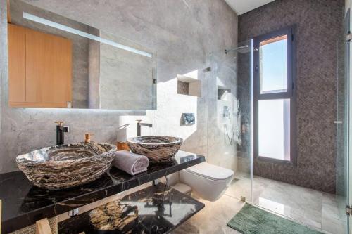 een badkamer met 2 wastafels en een toilet bij Villa Kassia , Jacuzzi, Hamman, jeux… in Marrakesh
