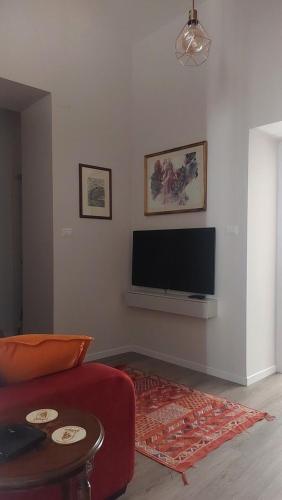 a living room with a red couch and a flat screen tv at ll Covo del Brigante in Melfi