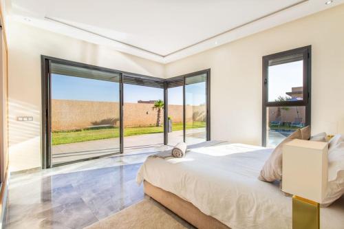 une chambre avec un grand lit et de grandes fenêtres dans l'établissement Villa Kassia , Jacuzzi, Hamman, jeux…, à Marrakech