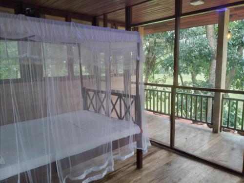 eine abgeschirmte Veranda mit einem Tisch und Fenstern in der Unterkunft Green Herbal Ayurvedic Eco-Lodge in Galle