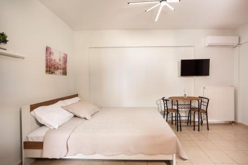 テッサロニキにあるAnopolh front apartmentのベッドとテーブルのある寝室
