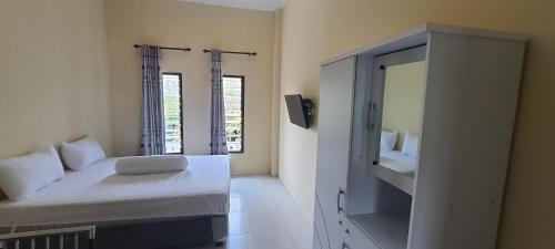 a small room with a bed and a mirror at Solo Nadamax City Guest House Syariah in Bonorejo