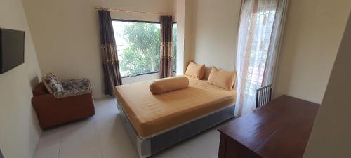 a small bedroom with a bed and a window at Solo Nadamax City Guest House Syariah in Bonorejo