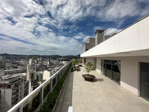 a balcony of a building with a view of a city at Stúdio Royal Central piscina/academia/coworking in Juiz de Fora