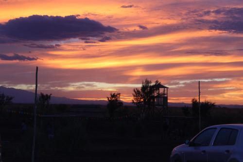 a sunset with a car parked in a parking lot at Finca La Celestita in Colonia Alvear