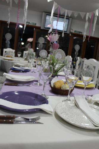 a table with purple plates and wine glasses on it at Finca La Celestita in Colonia Alvear