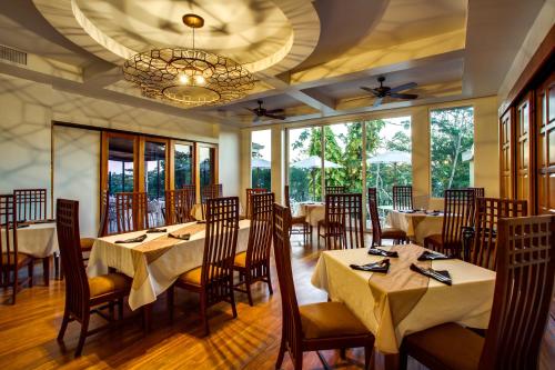 a restaurant with tables and chairs and a chandelier at San Ignacio Resort Hotel in San Ignacio