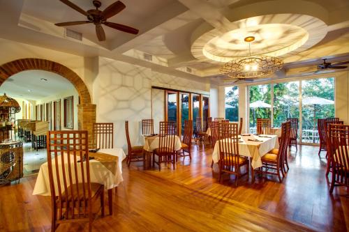 a restaurant with tables and chairs and a ceiling fan at San Ignacio Resort Hotel in San Ignacio