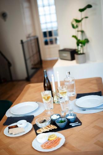 a table with plates of food and a bottle of wine at Hédoné Suite de luxe et Spa privatif in Nancy