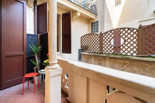a balcony of a house with a red stool at Appartamento elegante e centrale La Foglia D'Oro in Bologna