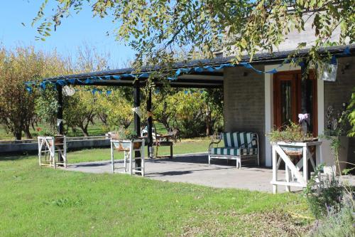 a pergola with chairs and a bench on a porch at Finca La Celestita in Colonia Alvear