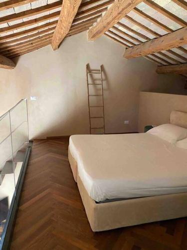 a bedroom with a white bed and a ladder at Olivietta Suite in Cervia