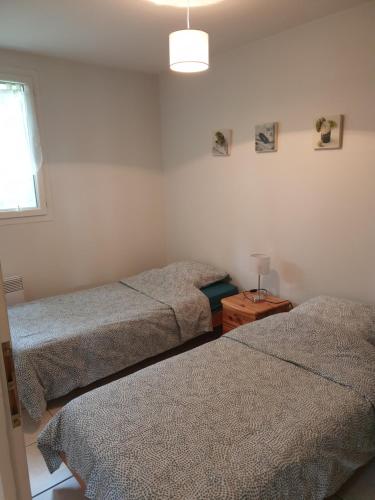 ein Schlafzimmer mit zwei Einzelbetten und einem Fenster in der Unterkunft Le Clos des Mimosas in Saint-Andéol-de-Vals