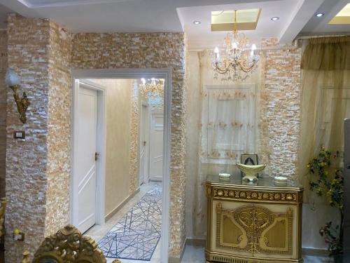 a hallway with a gold console and a chandelier at LuXury Apartment Agouza-Mohandesin in Cairo