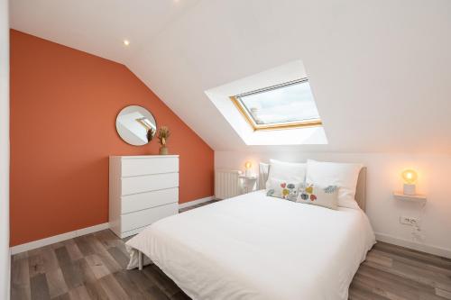 a bedroom with a white bed and a skylight at Duplex Petit-Fort - proche plage in Gravelines