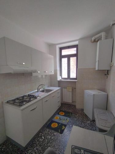 a kitchen with white cabinets and a sink and a refrigerator at B&B Sentiero Italia in Latronico