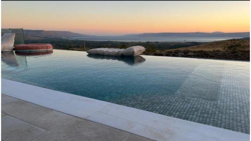 a swimming pool with a view of the ocean at נקודה בנוף - וילה פרטית in Had Nes