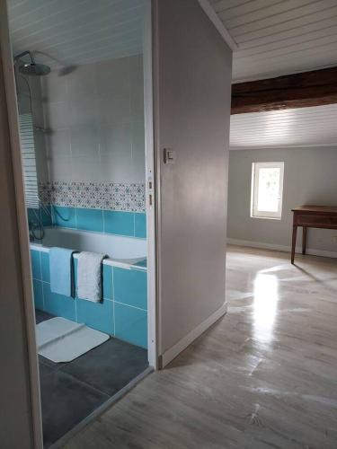 La salle de bains est pourvue de placards bleus et d'un lavabo. dans l'établissement Maisonnette, à Saintes