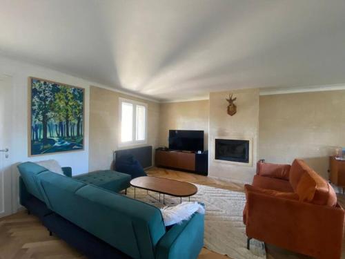sala de estar con sofá azul y mesa en Belle villa avec grande piscine 12 couchages 100m du tram, en Le Bouscat