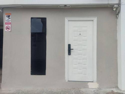 uma porta branca do lado de um edifício branco em Suite independiente en ciudadela privada em Guayaquil