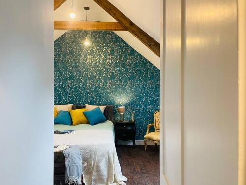 a bedroom with a bed with a blue wall at Beautifully restored beach side Victorian house! in Torcross