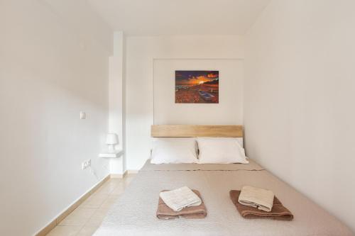 een witte kamer met een bed met handdoeken erop bij Anopolh apartment 11 in Thessaloniki