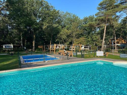 een zwembad met een speeltuin in een park bij De Bosuil in Zuidwolde
