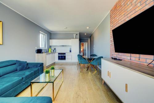 a living room with a blue couch and a brick wall at Allure Nautica Aparthotel in Szczecin